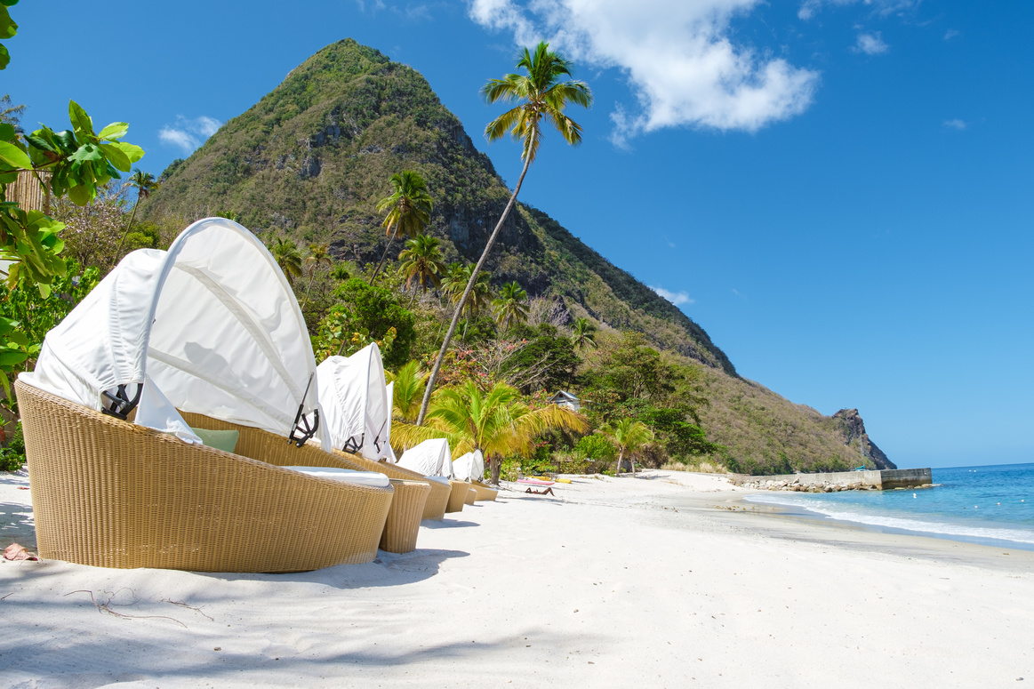 Sugar beach Saint Lucia ,white tropical beach palm trees and luxury beach chairs St Lucia Caribbean